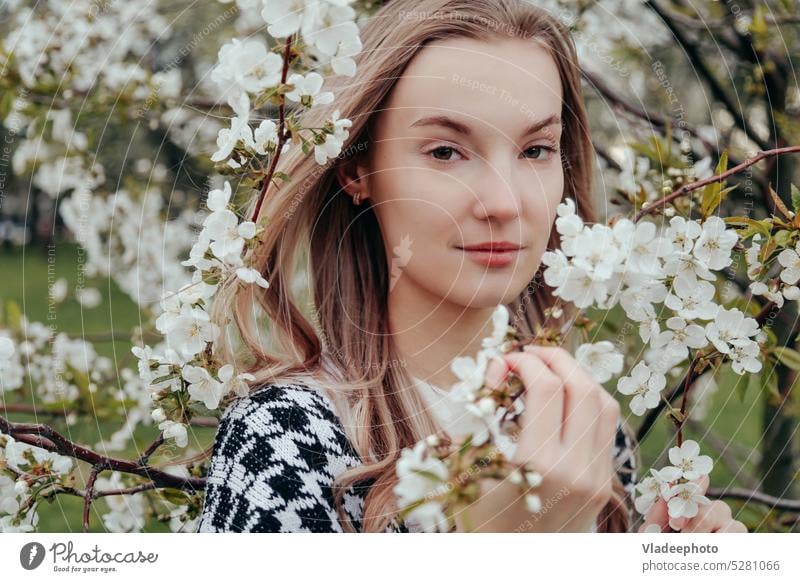 Portrait of Blonde Woman with Closed Eyes, Standing Among the Blooming Trees. nature beauty spring woman close eyes enjoy young garden blonde apple cherry