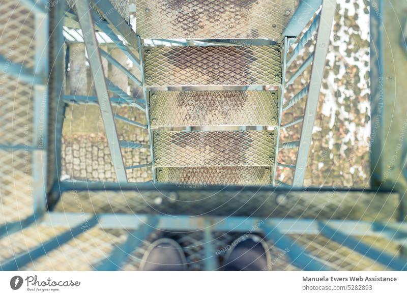 A view down the staircase of a metal observation tower Stairs stagger stair treads Scaffolding out outdoor Tower climbing tower Lookout tower Tin rail Turquoise
