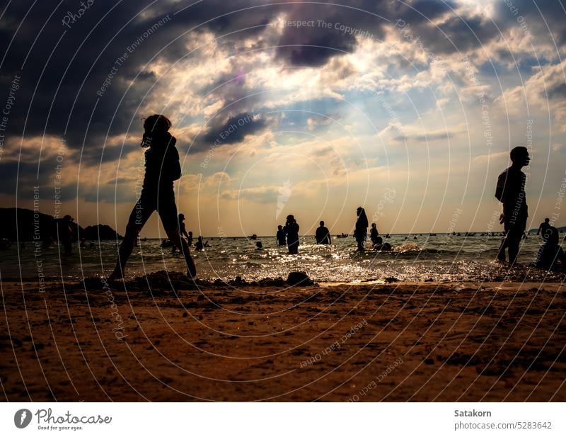 Silhouettes of people playing in the sea at a public beach silhouette landscape sky sand evening vacation sun sunset summer young ocean water nature sunlight