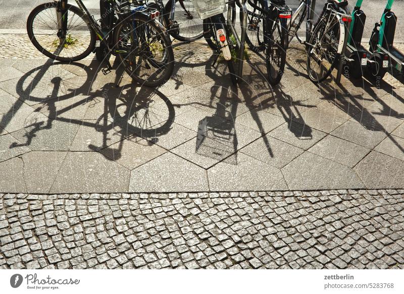 Bicycles and their shadows Parking lot Berlin Sidewalk Office city Germany Bicycle rack Building off Capital city House (Residential Structure) downtown Kiez