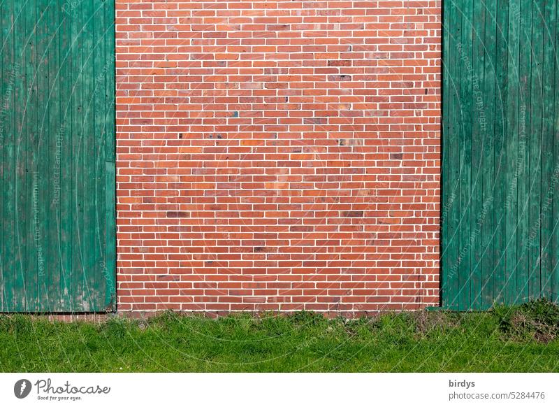 Brick wall between two green barn doors background Copy Space Wooden gates Facade Barn facade Grass Background picture Bricks clinker Wall (building)