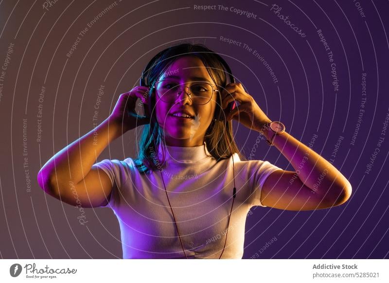 Young woman wearing headphones while listening to music smile confident young gadget glad meloman modern song melody cool individuality vibrant millennial