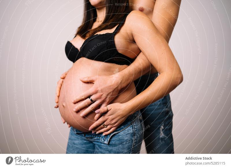 Crop man embracing pregnant woman with bare belly couple hug touch belly embrace await love care expect peaceful young harmony gentle relationship prenatal