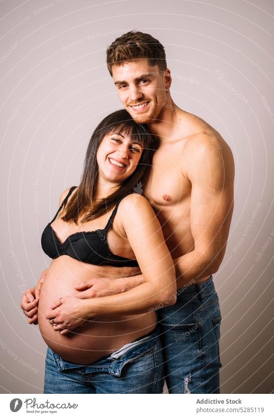 Man embracing pregnant woman with bare belly couple hug touch belly embrace await love care expect peaceful young harmony gentle relationship prenatal maternal