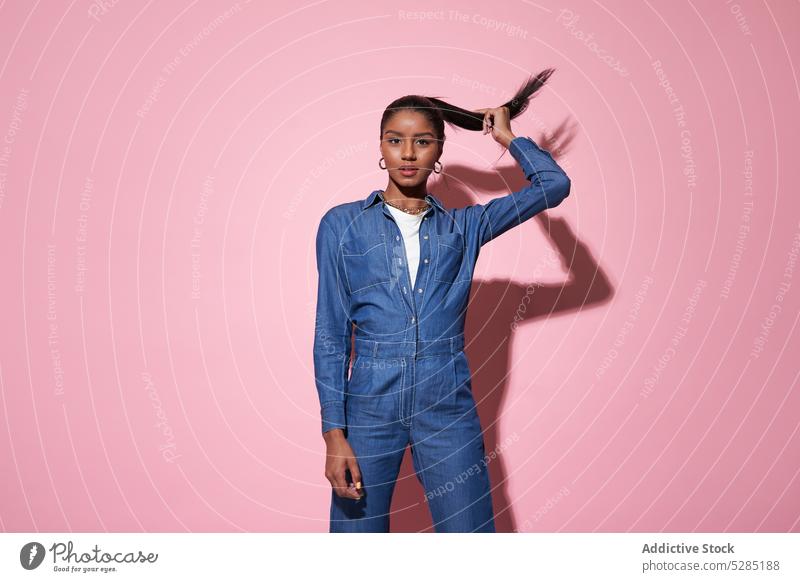 Stylish black woman touching hair during photo session style confident touch hair model trendy fashion denim suit outfit female young african american