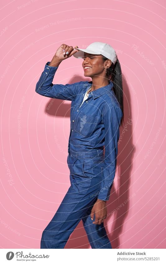 Happy stylish black woman in white cap in studio style denim fashion trendy outfit model cheerful apparel smile appearance jeans female ethnic young
