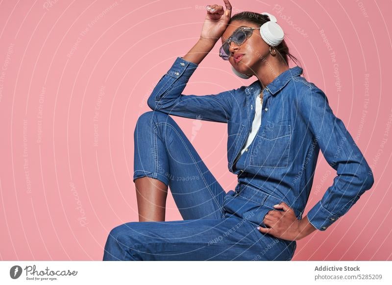 Stylish black woman in headphones and sunglasses listen style music model fashion trendy denim african american ethnic young female modern outfit device gadget