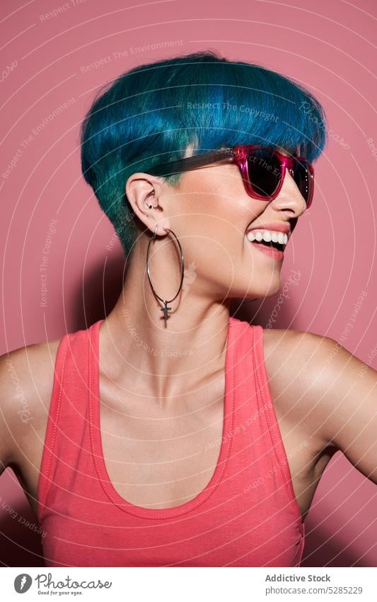 Cheerful woman with blue hair in studio excited having fun active sunglasses studio shot cheerful unique joy eyewear smile positive happy female young free time