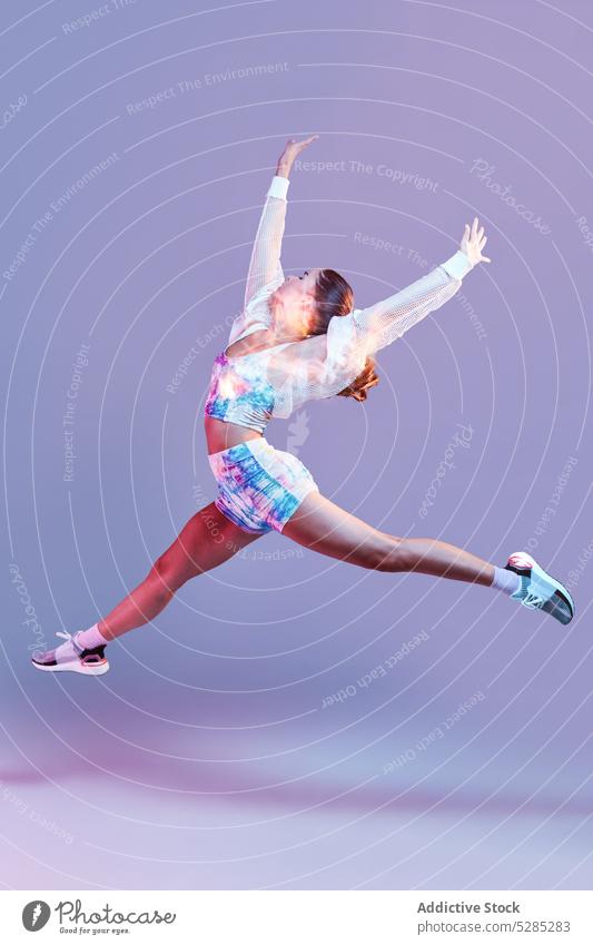 Energetic woman jumping in studio run leg raised training fast activity raised arms active healthy lifestyle studio shot sportswoman female young vitality slim