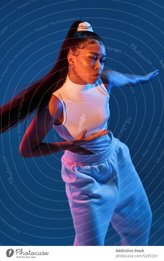 Mixed race woman dancing in studio dancer perform studio shot arms outstretched choreography move practice training active personality lady young outfit