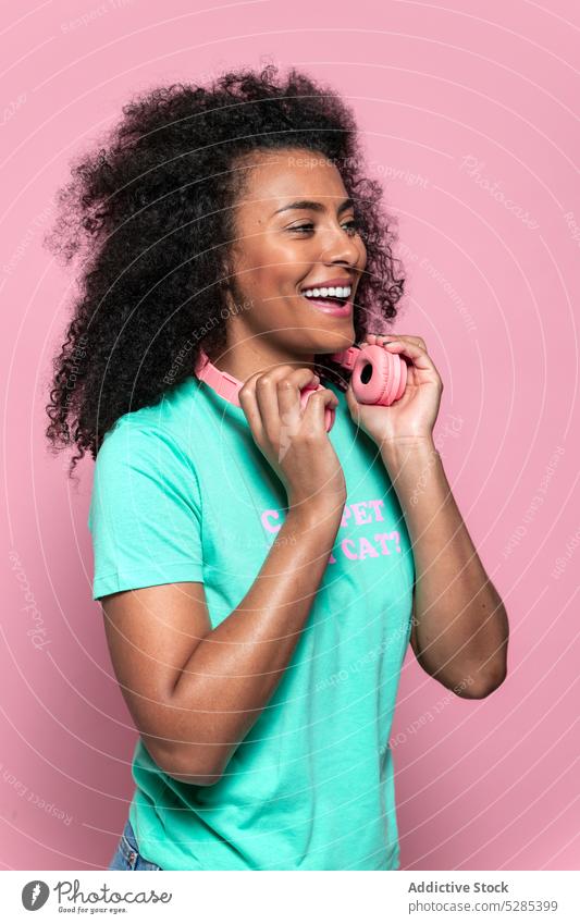 Confident black woman with headphones pensive calm style thoughtful studio serious portrait casual young female confident african american ethnic trendy afro