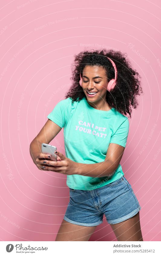Delighted black woman taking selfie on smartphone music listen headphones smile happy cheerful eyes closed african american female young ethnic device gadget