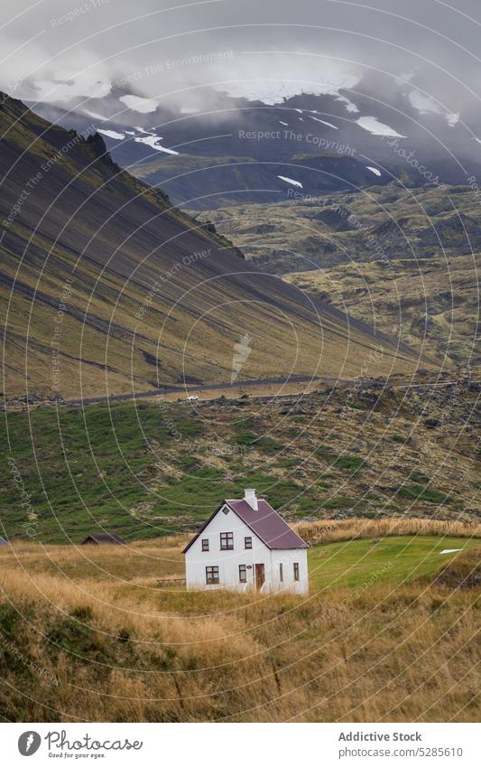 Big house in mountainous valley cottage village settlement nature landscape picturesque countryside scenery peaceful scenic highland sun green idyllic iceland