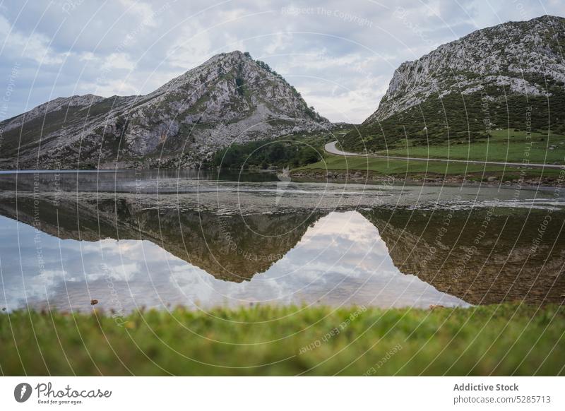 Calm lake reflecting rocky mountains under overcast sky landscape range nature highland valley picturesque ridge peaceful scenery lakes of covadonga asturias