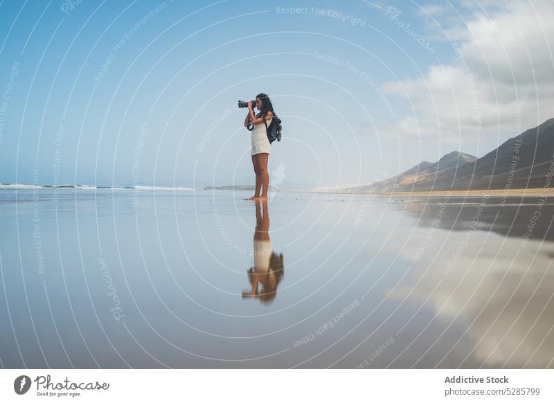 Woman taking picture of sea on photo camera woman photographer take photo moment memory shore coast traveler female young ocean vacation seashore freedom