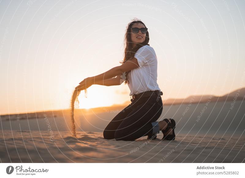 Happy woman playing with sand beach smile sunset cheerful summer happy sea coast female vacation sunglasses casual relax bali rest evening joy holiday weekend