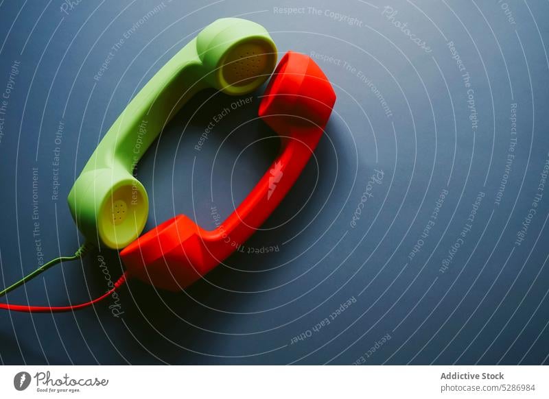 Red and green telephone handsets placed on table retro love support close connection distance relationship vintage concept creative romantic nostalgia minimal