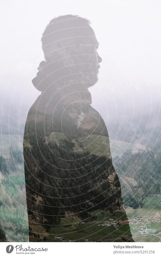 Double exposure male silhouette in a hood portrait close-up on mountains background.Mountain landscape and silhouette of a man.Human and nature double exposure