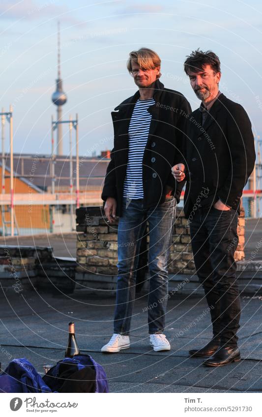Two men on the roof . In the background the TV tower in the foreground a bottle of wine Berlin Prenzlauer Berg Man Television tower two Roof Downtown