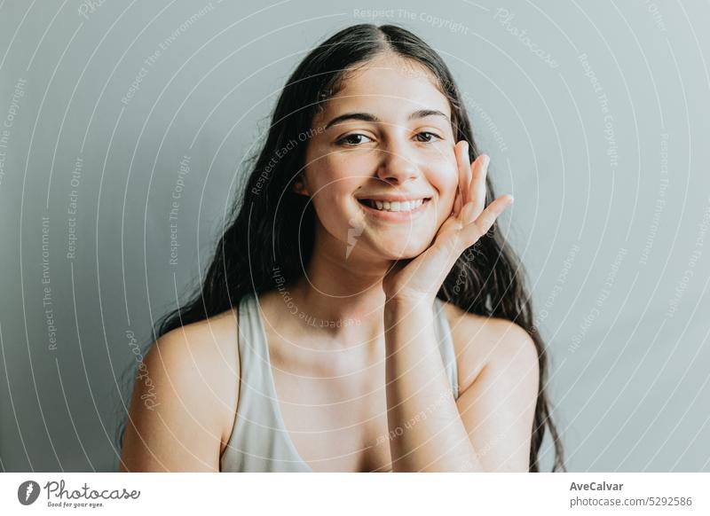 Portrait of model, with hand in face relaxed after dermatology skin treatment. Young adult woman skincare glow from spa rituals, posing with glowing, clean and clear skin and no makeup.
