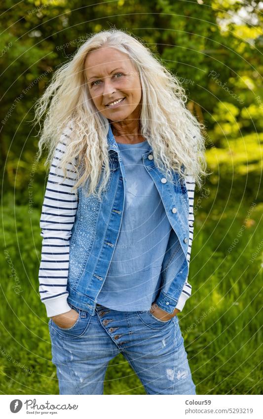 Woman with her hands in pocket one person happiness natural beauty lady enjoyment female woman meadow people lifestyle happy senior background elderly relax