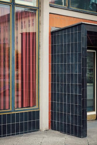 Entrance of a building of post-war modernism with black tiles, window, curtain Post-war modernism Architecture Black Orange Drape shape Geometry Window