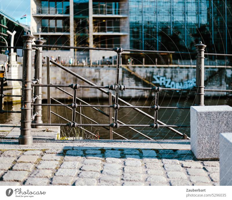 View of railings in front of the river Spree near the government district, behind modern buildings in Berlin-Mitte forged Downtown Berlin Modern Facade River