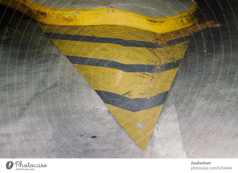 Yellow lane marking in the form of a spike in front of paragraph on the concrete floor of a parking garage Traffic lane Lane markings zipfel Stripe Stage