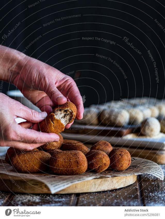 Crop persons hands splitting croquette pork cheek show piece crispy portion board bread crumb snack yummy homemade fast food dish culinary kitchen roll meat