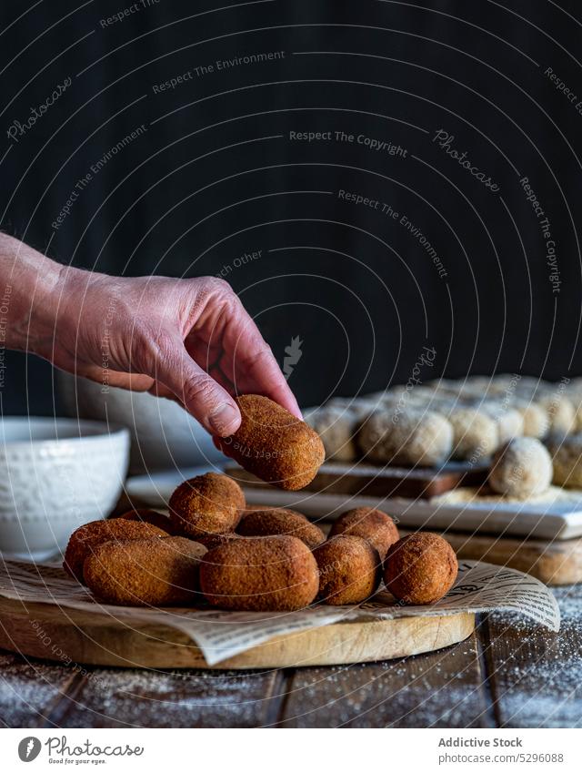 Crop person hands holding croquette pork cheek show piece crispy portion board bread crumb snack yummy homemade fast food dish culinary kitchen roll meat