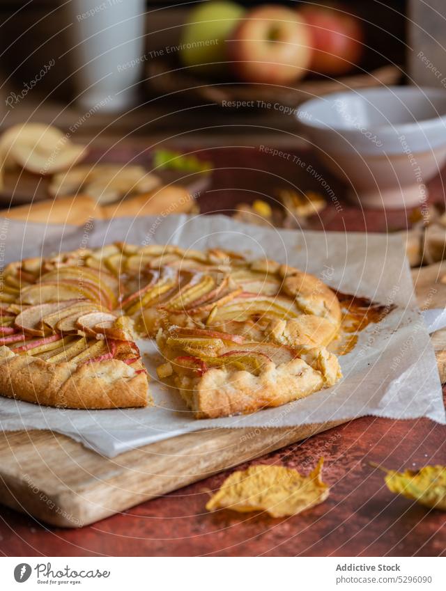 Freshly baked apple pie on baking paper autumn leaf shortcrust homemade cutting board pastry galette rolling pin delicious fresh recipe piece domestic kitchen