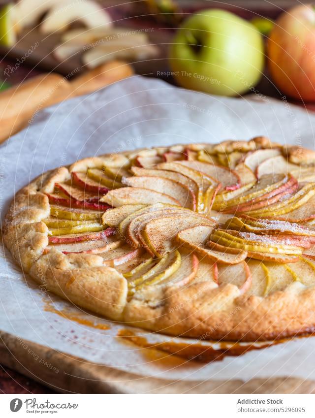 Freshly baked apple pie on baking paper autumn leaf shortcrust homemade cutting board pastry galette rolling pin delicious fresh recipe piece domestic kitchen