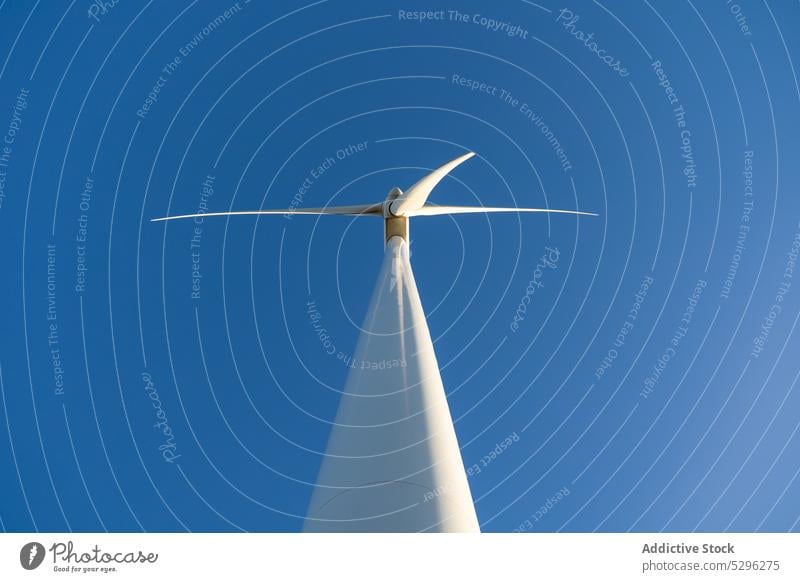 Wind turbine against blue cloudless sky wind alternative energy blue sky generator ecology production resource power environment sustainable propeller rotate