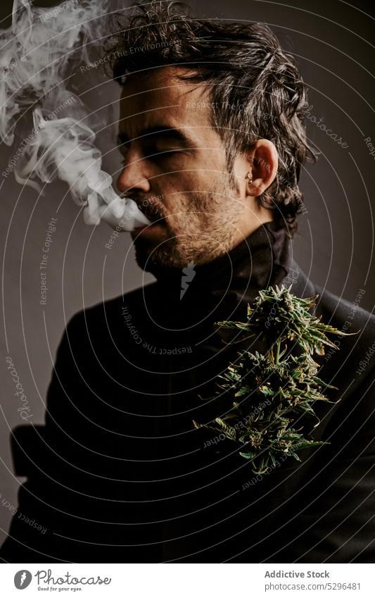 Bearded man smoking marijuana in dark room smoke cigarette smoker inhale exhale habit addict drug adult male dark hair enjoy fragrant brunet herb medical ganja