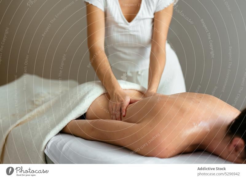 Crop therapist doing body massage to female client in spa salon women back relax masseur procedure rehabilitation therapy treat specialist patient calm care