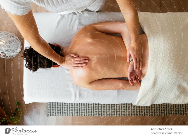 Masseuse massaging back of client at salon women relax massage masseur spa therapy therapist topless recovery relief rest procedure body care treat pleasure