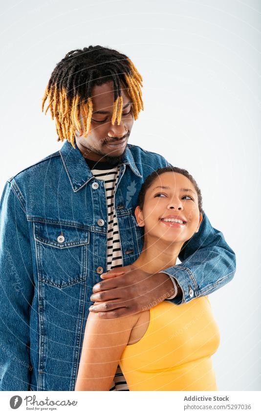 Happy ethnic couple embracing on white background boyfriend girlfriend smile relationship embrace hug happy jeans street style cheerful denim african american