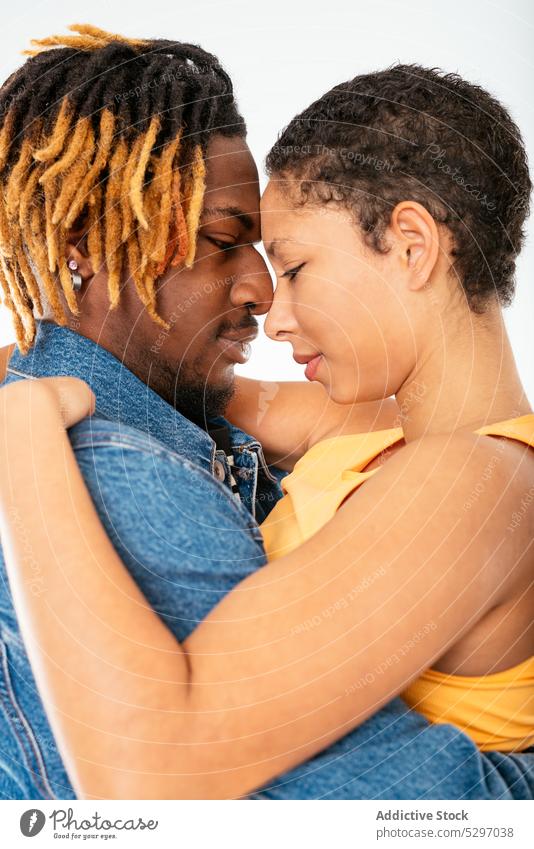 Happy ethnic couple embracing on white background boyfriend girlfriend smile relationship embrace hug happy jeans street style cheerful denim african american