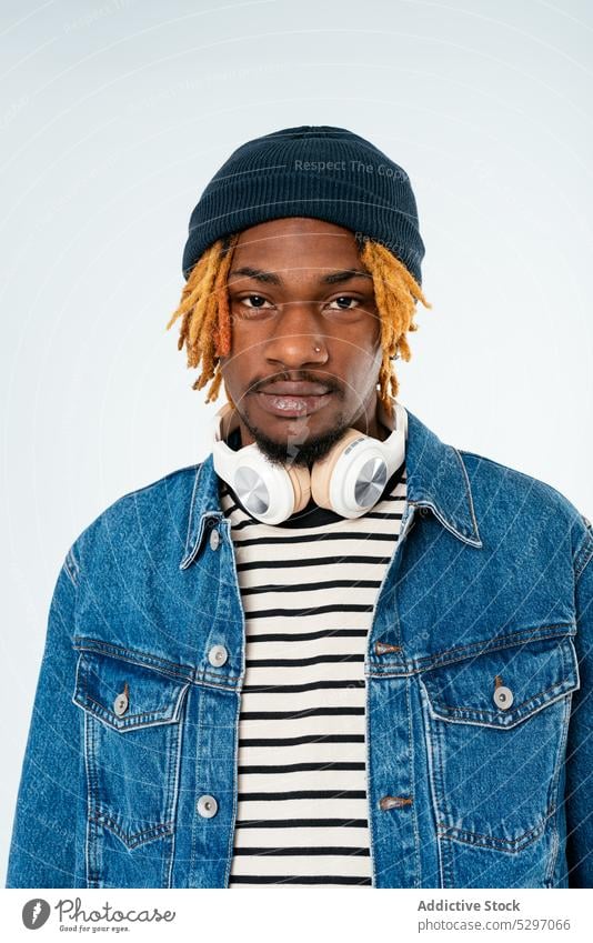 Stylish black man with dreadlocks in denim jacket style outfit smile street style cool studio shot confident african american ethnic casual appearance male hat