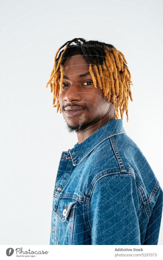 Stylish black man with dreadlocks in denim jacket style outfit smile street style cool studio shot confident african american ethnic casual positive appearance