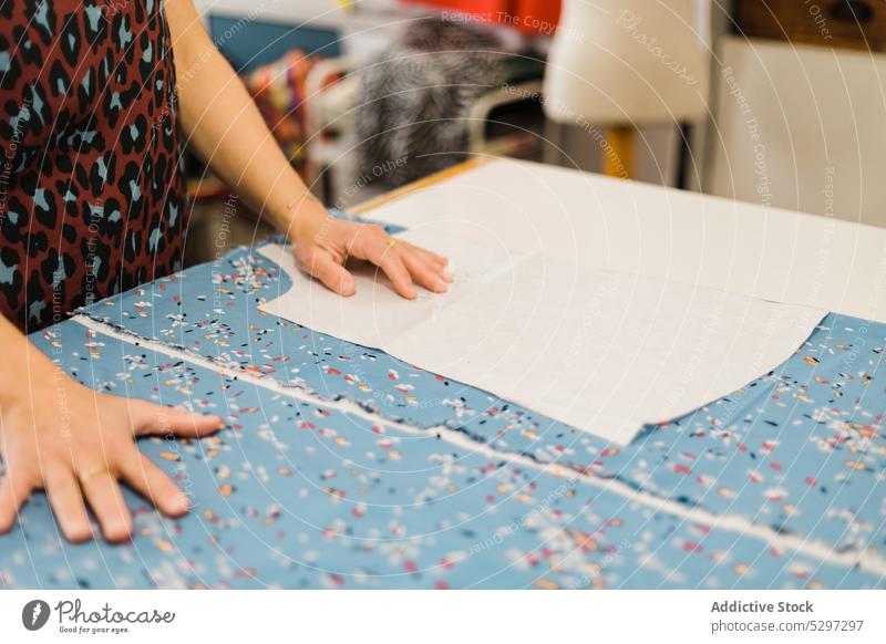 Anonymous woman preparing pattern for sewing in atelier seamstress designer fabric dressmaker cloth workshop textile tailor creative material craft