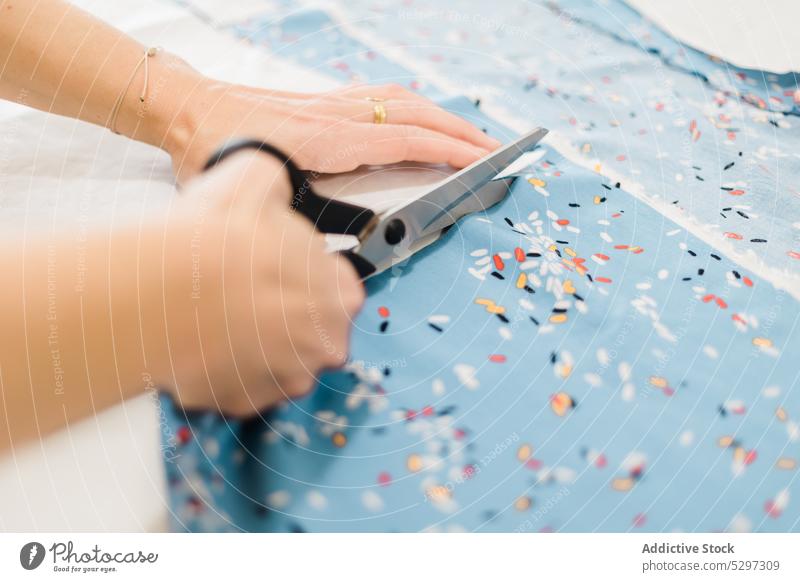 Unrecognizable designer cutting fabric in atelier dressmaker studio tailor scissors pattern cloth workshop small business textile material seamstress tool craft