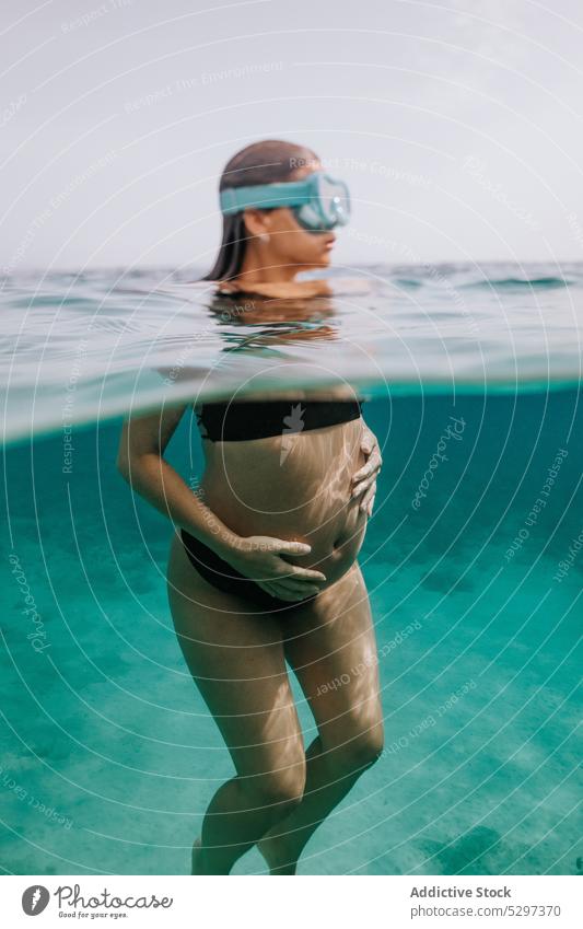 Unrecognizable pregnant woman diving in sea swim underwater fish dive undersea vacation bikini female transparent blue holiday reef enjoy belly exotic ocean