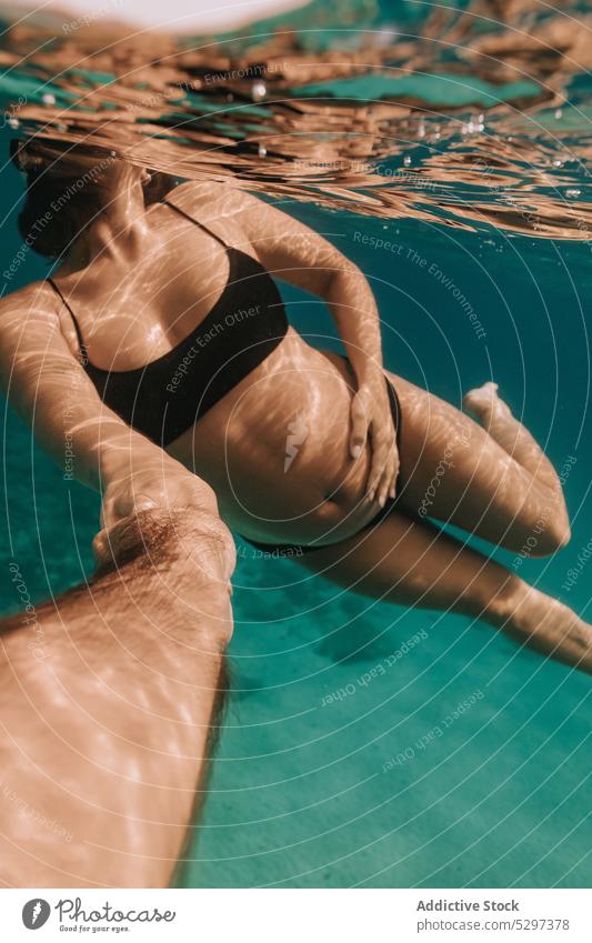 Unrecognizable pregnant woman taking selfie in sea swim underwater summer vacation holiday swimwear female resort turquoise tropical clear bikini belly expect