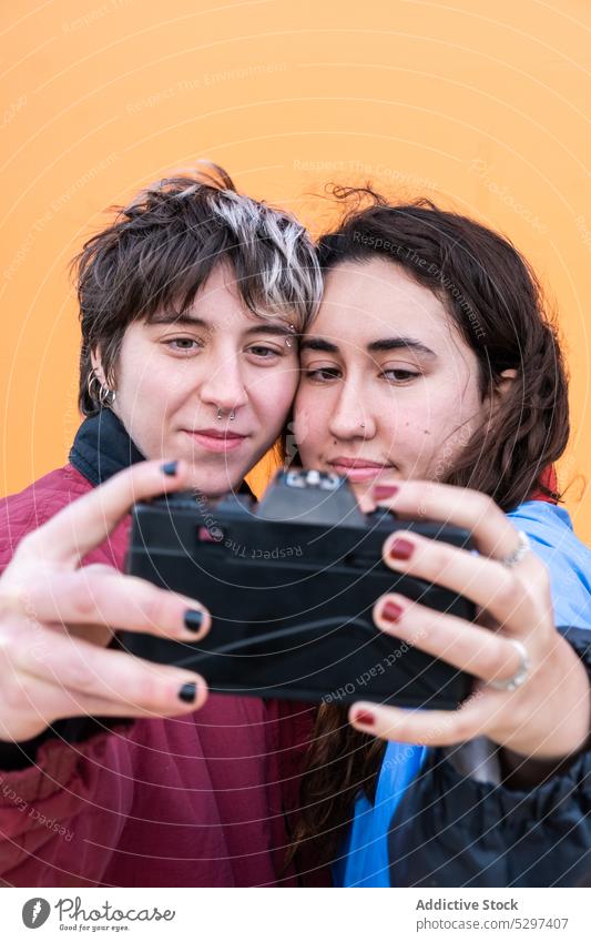 Young lesbian couple taking selfie on film camera photo camera memory take photo lgbt love relationship positive young homosexual girlfriend photography moment