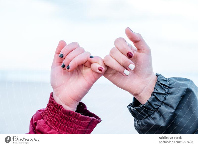 Crop girlfriends making pinkie promise sign couple hand lesbian pinky finger friendship love forever holding hands trust care solidarity support symbol gesture