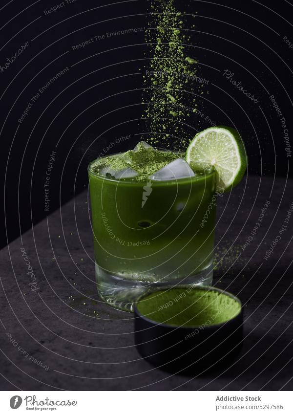 Glass of cold matcha tea with lime ice drink refreshment beverage cool ingredient citrus powder cube water freeze frozen delicious fruit dark tasty liquid