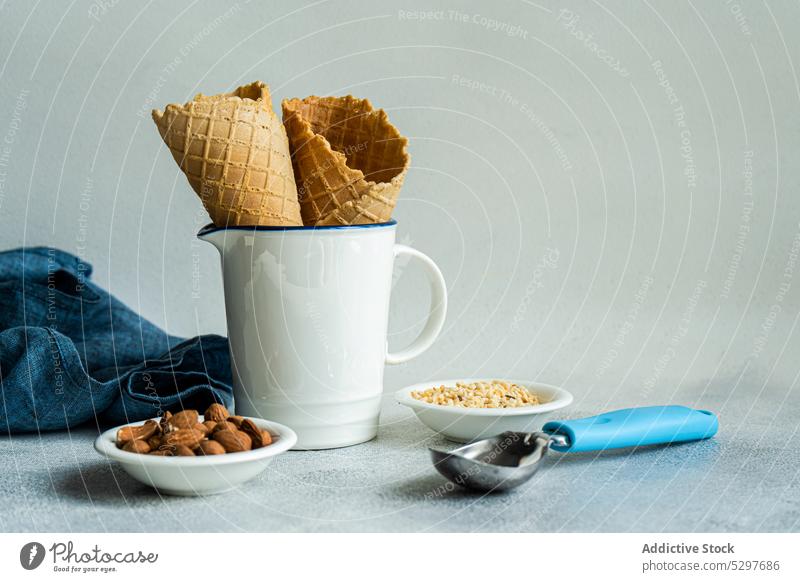 Waffle cones and nuts for ice cream cooking waffle almond chopped cold concrete cup delicacy dessert eat food gourmet homemade ingredients napkin scoop spoon