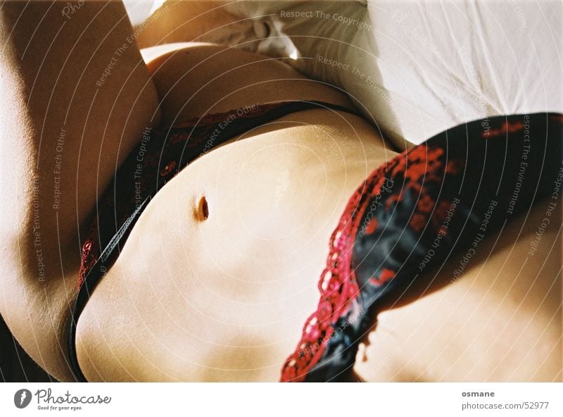 Foto de Nude woman wearing panties on bed do Stock