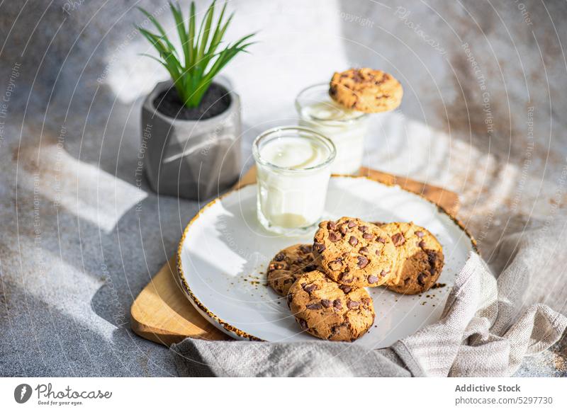 Healthy oat cookies with chocolate beverage black board cutting board dessert drink eat eating food glass healthy milk natural oatmeal plate rustic snack sunny